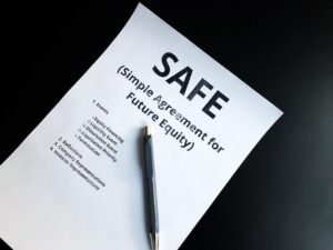 A homeowner reviews papers and photos at a kitchen table after an insurance claim denial letter.