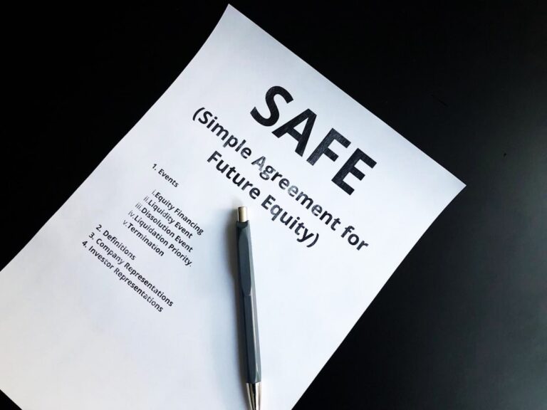 A homeowner reviews papers and photos at a kitchen table after an insurance claim denial letter.