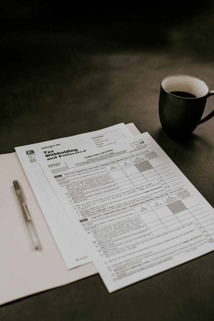 A person reviews paperwork and photos at a kitchen table, preparing documents for an insurance claim.