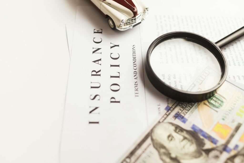 Homeowner reviews repair estimates and claim documents at a kitchen table beside photographs of property damage.
