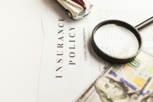 Homeowner reviews repair estimates and claim documents at a kitchen table beside photographs of property damage.
